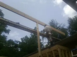 Carpenter setting a ridge beam over a new addition frame — Ice Dam Removal by Roofing Brothers in Blythewood