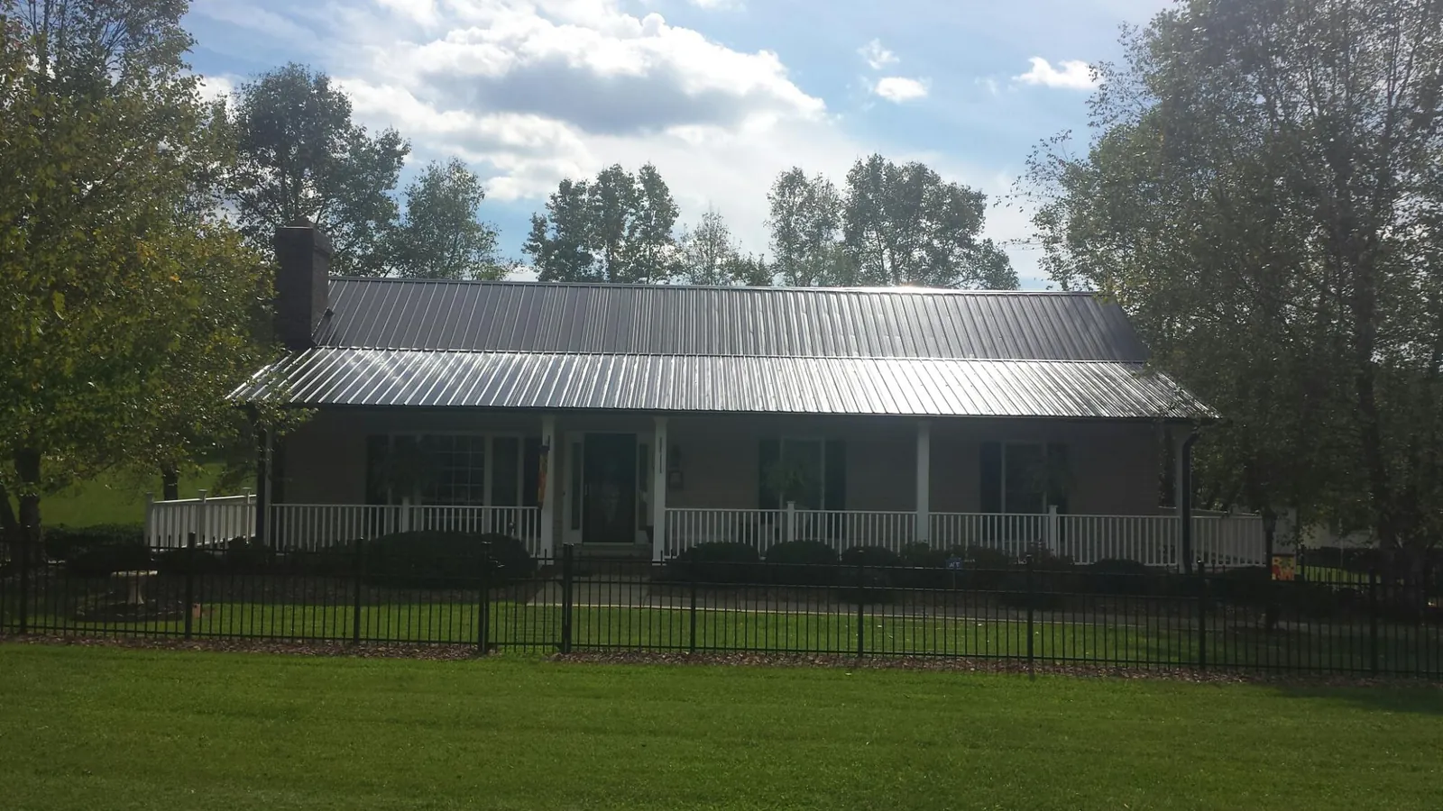 Gray metal roof on a brick ranch with a full width front porch — Gutter Guard Installation work by our crew in Blythewood
