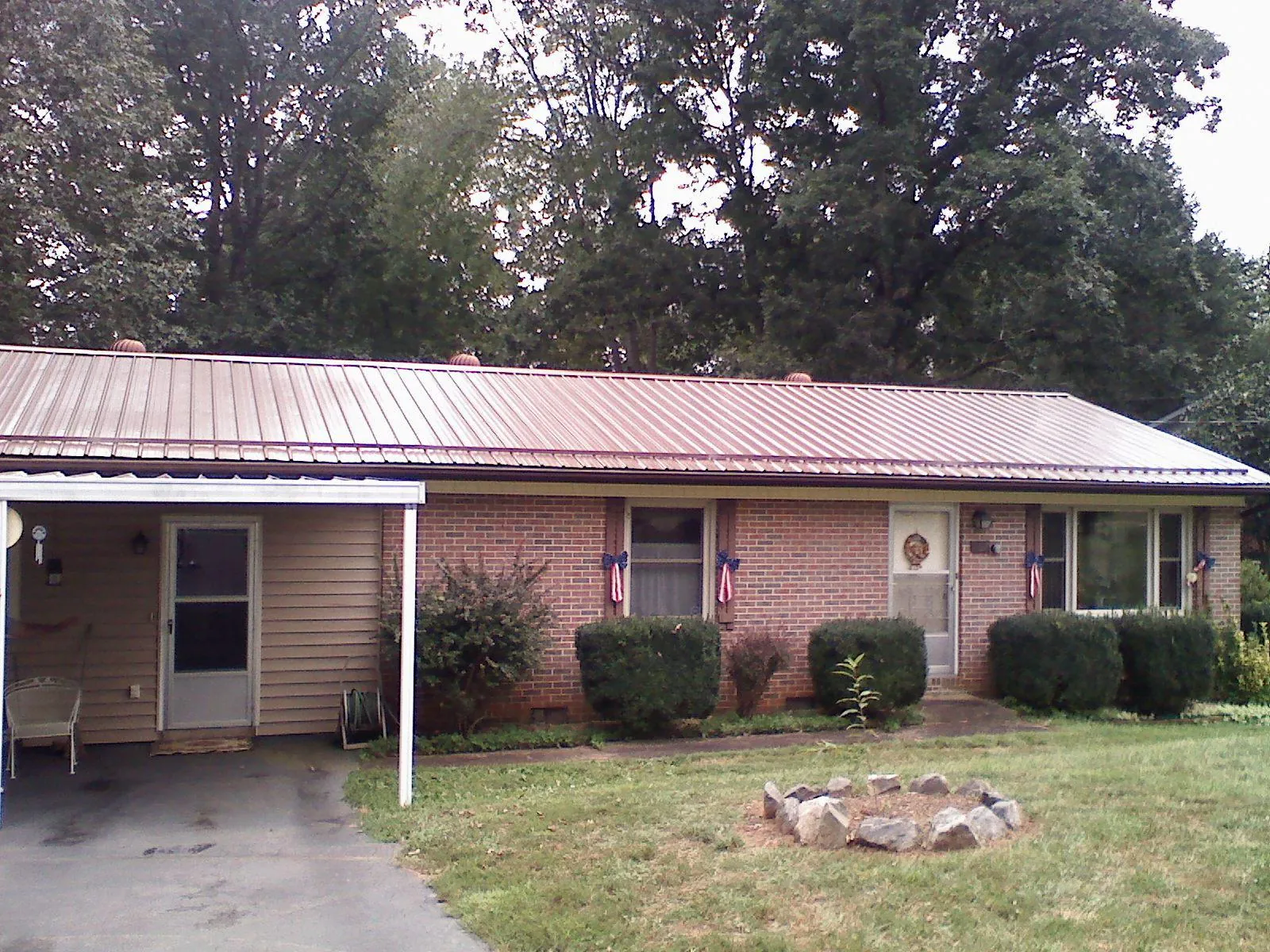 Bronze metal roof and carport on a brick ranch home — Roof Repair work by our crew in Blythewood
