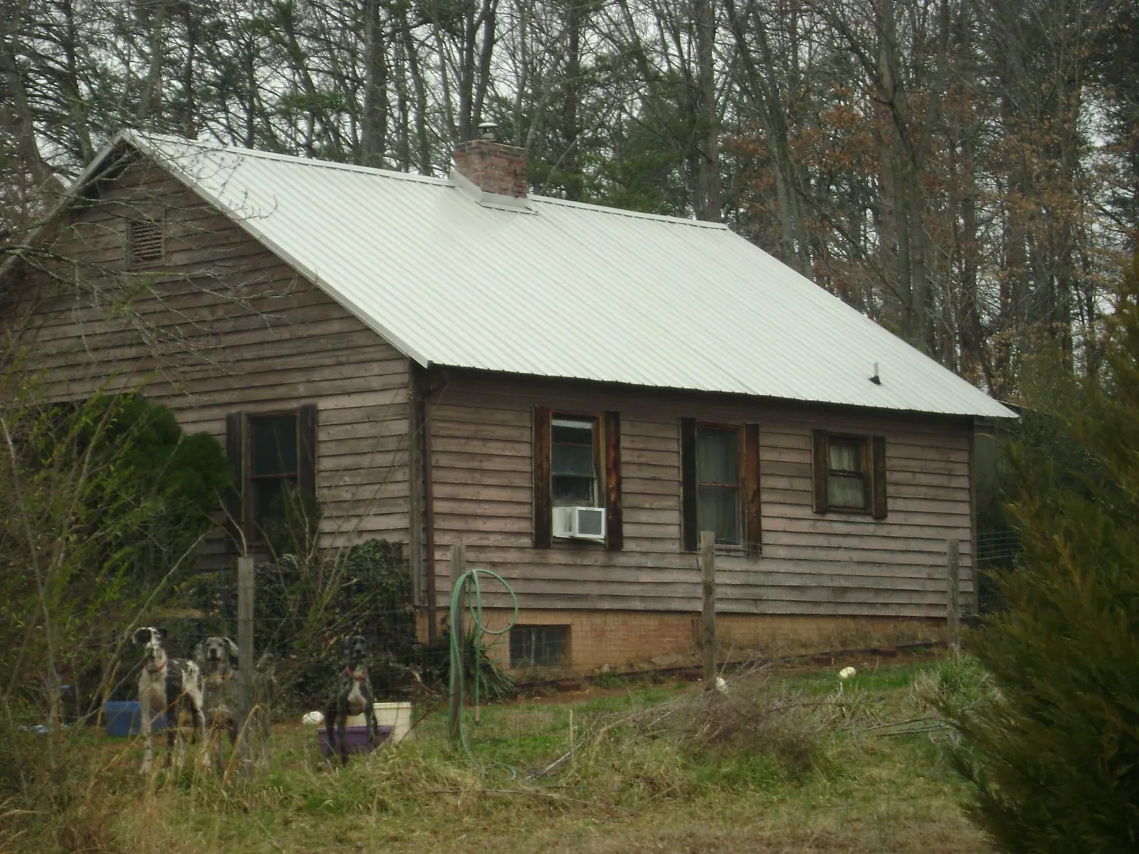 White metal roof on an old wood sided farmhouse, from a Metal Roof Installation job in Blythewood